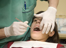 Dental professional examining a young female patient’s teeth.