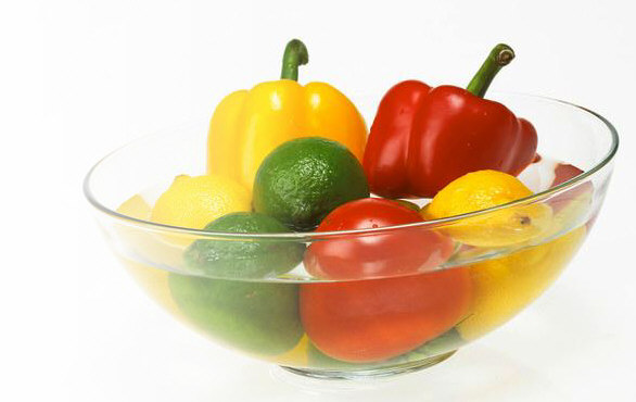 Yellow and green peppers, 3 limes, a lemon, and a tomato representing vitamins