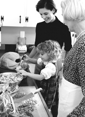 Photo of grandmother, mother, and daughter stuffing a turkey.