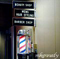 Barber pole outside the beautyand barber shop on the lower floor.