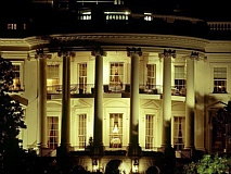 The White House from the back lit up at night with a golden glow.