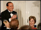 Prime Minister Silvio Berlusconi of Italy, seated next to Mrs. Laura Bush, acknowledges a toast offered in his honor by President George W. Bush Monday evening, Oct. 13, 2008, at the White House State Dinner in honor of Berlusconi's visit to Washington, D.C. White House photo by Chris Greenberg