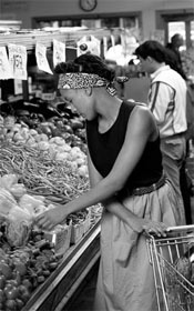 Photo of woman buying vegetables at market.