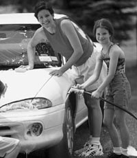 Photo of woman and girl washing a car.