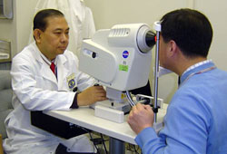 Manuel B. Datiles III, M.D., NEI medical officer, demonstrates the dynamic light scattering (DLS) device.  NEI and the National Aeronautics and Space Administration (NASA) collaborated to develop this simple, safe eye test for measuring a protein related to cataract formation.