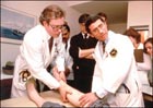 Drs. Lee Hall (left) and Anthony S. Fauci (right) examine participant in an early AIDS study