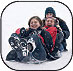 Image of teenagers sliding down snowy slope