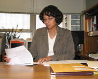 Kelli works at her desk, reviewing material for an electronic bulletin that highlights NIH sponsored public activities.