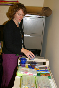 Megan gathers art supplies for bedside therapies.