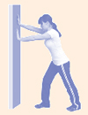 Mujer haciendo flexiones contra la pared