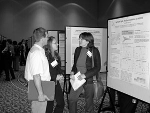 Anna Simon discusses a poster about her research on immunoglobulins with meeting participants