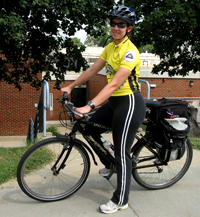 Angela parks her bike in front of her building on the NIH campus and sports an NIH Bicycle Commuter Club jersey.
