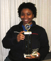 Keisha holds the first place trophy she won in an Toastmasters International contest.