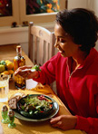 Photo of a woman eating a salad at home