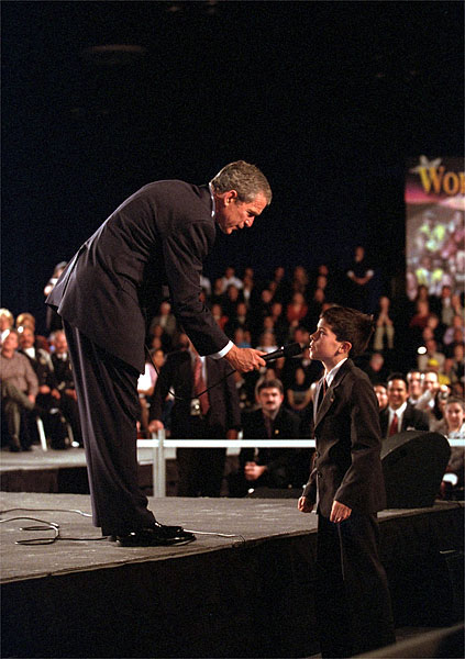 President George W. Bush holds the microphone for a boy during a town hall meeting in Ontario, Calif., Jan. 5. The President spoke about and listened to comments concerning the economy, immigration and the war in Afghanistan. White House photo by Eric Draper.