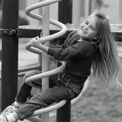 A young girl plays on a jungle gym