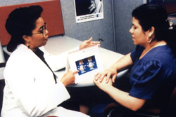 Doctor sitting down showing patient illustration of human eyes