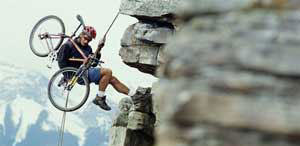 Photo of a mountain climber carrying a bike