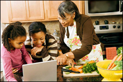 Photo: Mother and daughters gathered around a computer.