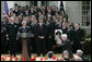 President George W. Bush and the Midshipmen of the U.S. Naval Academy's football team, break out in laughter as Sen. John McCain, R-Ariz., acknowledges his late arrival Wednesday, April 20, 2005, to the Rose Garden presentation of the Commander-in-Chief Trophy. The trophy is awarded after each season to the service academy with the best overall record against the other two. White House photo by Paul Morse