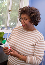 Woman looking at a pill bottle.