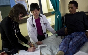 A Fogarty grantee and trainee write down statistics for a patient in South Africa. Photo by David Rochkind.