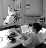 Photo: Doctor tending to a patient in patient care unit.