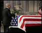 Newsman Tom Brokaw places his hand on the casket of former President Gerald W. Ford, as he makes his way to the lectern to deliver his remarks during the State Funeral service Tuesday, Jan. 2, 2007, at the National Cathedral in Washington, D.C. White House photo by Eric Draper