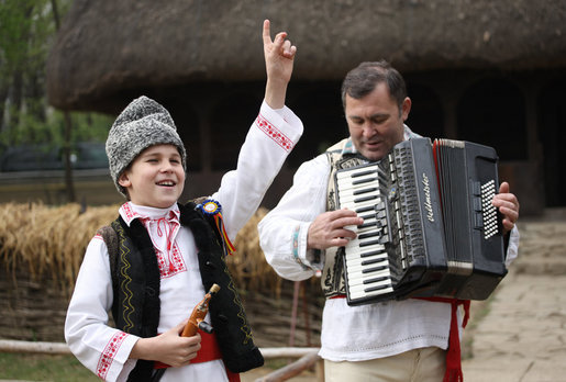 A young boy sings and dances as he’s accompanied by an accordionist during a performance for the official NATO Spouses’ Program Thursday, April 3, 2008, at the Dimitrie Gusti Village Museum in Bucharest. White House photo by Shealah Craighead