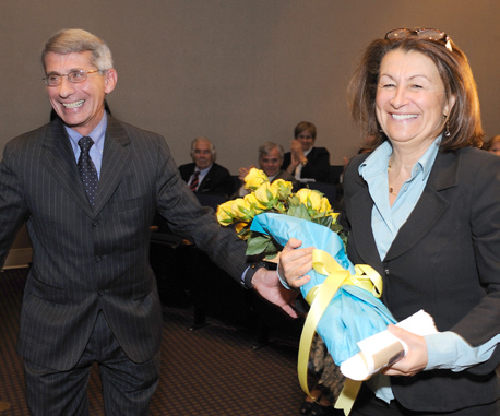 NIAID director Dr. Anthony Fauci presents a bouquet of yellow roses to Dr. Nadia Zerhouni, following his remarks.