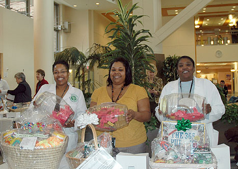 Clinical Center emplouyees showing off gift basket treasures 