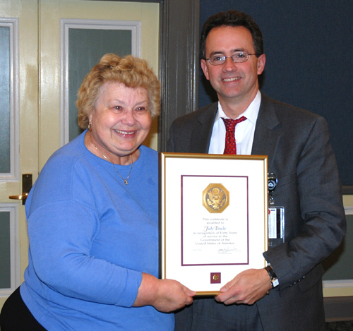 Judy Fouche accepts her 40-year award as a federal employee in November 2007 from John Burklow, NIH associate director for communications and public liaison.