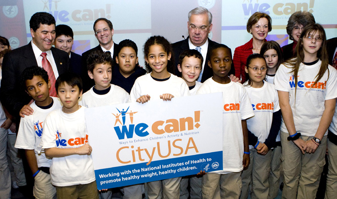 Children from Umana Middle School Academy present the Boston We Can! City sign to Mayor Thomas Menino during a press conference. Adults on hand included (from l) NIH director Dr. Elias Zerhouni; acting Surgeon General Steven Galson; Menino; NHLBI director Dr. Elizabeth Nabel; and Karen Donato, coordinator, NHLBI Obesity Education Initiative.