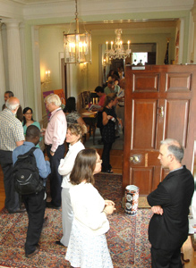 Guests fill Stone House entryway for party.