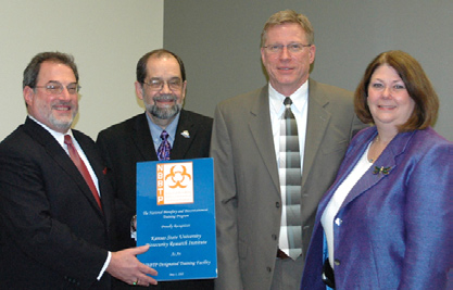 On hand at the dedication of the new NIH-sponsored biosecurity institute at Kansas State University were (from l) Murray Cohen, president of Frontline Healthcare Workers Safety Foundation, which serves as the government contractor for the facility; Ron Trewyn and Scott Rusk of K-State; and Dr. Deborah Wilson, director of ORS’s Division of Occupational Health and Safety.
