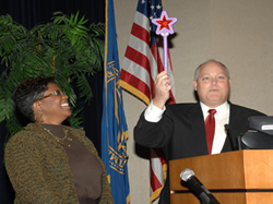 Jeff Linden of NBS gives Shante Thompson of NBS a magic wand “for making problems disappear.”