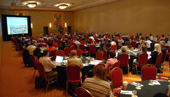 Image from the technology fair in 2007, showing a room of people watching a presentation.