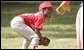 Taylor Paige Nevils of South Side Little League Memphis Red Sox from Chicago, peers up at Dugout, the Little League mascot, during a T-ball game on the South Lawn Sunday, June 26, 2005. White House photo by Paul Morse