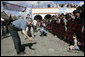 President George W. Bush tries to coax a shy young boy from the crowd Monday, March 12, 2007, during his visit with Mrs. Laura Bush to Santa Cruz Balanya, Guatemala. White House photo by Eric Draper