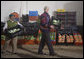 President George W. Bush wearing a Hupile, a handmade, traditional jacket, lends a hand loading crates of lettuce Monday, March 12, 2007, during a visit to the Labradores Mayas Packing Station in Chirijuyu, Guatemala. The jacket was presented to him earlier in the day by the director of the Dr. Richard Carroll Library in Santa Cruz Balanya. White House photo by Paul Morse