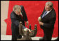 President George W. Bush lays a white rose in the palm of the Peace Statue as Guatemalan President Oscar Berger looks on Monday, March 12, 2007, at the Palacio Nacional de la Cultura in Guatemala City. White House photo by Paul Morse