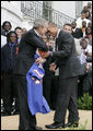 President George W. Bush takes a hand off of a game ball from University of Florida Gators quarterback Chris Leak, during ceremonies Monday, March 19, 2007 on the South Lawn of the White House, to honor the 2006 NCAA football championship team. White House photo by Eric Draper