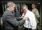 President George W. Bush presents the Purple Heart to U.S. Army Sgt. Bruce Dunlap of Kansas City, Mo., during a visit Friday, March 30, 2007, to the Walter Reed Army Medical Center in Washington, D.C. Dunlap was injured during convoy operations in southern Baghdad. White House photo by Eric Draper