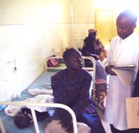 A clinician examines a child hospitalized with a fever possibly caused by malaria.