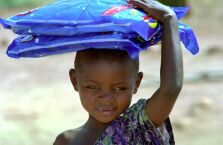 Zambian child carrying bednets