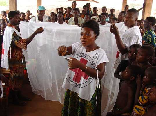 Picture: Togolese Red Cross volunteers demonstrate how to properly use an insecticide-treated bednet to prevent malaria, a leading cause of disease and death in Togolese children.