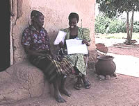 A health worker interviewing a woman outside her house during a community survey