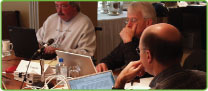 group of people around a table working on laptop computers