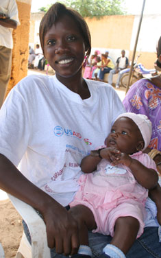 A woman and child participate in an insecticide-treated net retreatment launch in Thies, Senegal. 