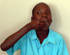 Steven, in Uganda, taking his first dose of artemisinin-based combination therapies (ACTs) at the hospital with a cup of water -- treatment for three days will completely eliminate the malaria parasites from his body. 